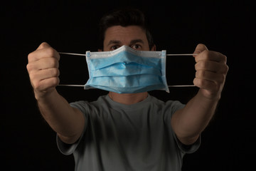 a man shows a protective mask on his hands