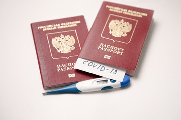 Coronavirus Quarantine and travel concept. Passport with COVID-19 inscription. Coronavirus COVID-19 pandemic. Fever, coronavirus symptoms and travel.