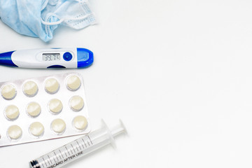 Obraz premium Facial protective mask, syringe, thermometer and pills. Flat lay and copy space concept. Pharmacy theme.