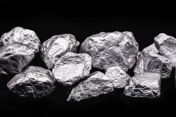 Raw manganese. Manganese stone isolated on black background. Mineral extraction of heavy metals...