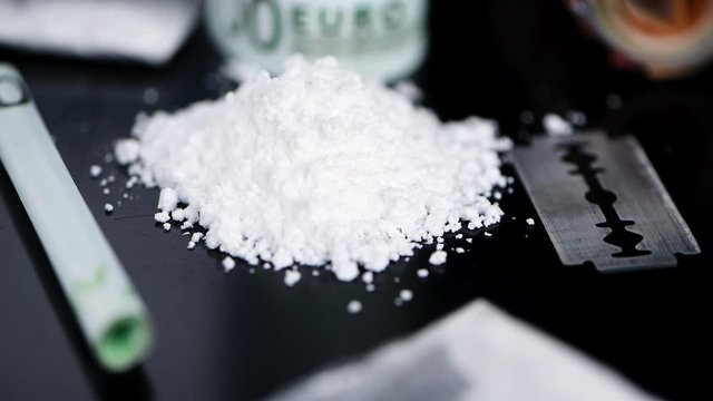 Portion of rotating Cocaine on a dark plate (seamless loopable)