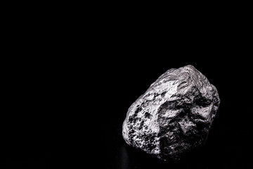 large silver stone, rare silver nugget on black background. Gemstone in high resolution, luxury concept.
