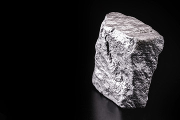 Raw manganese. Manganese stone isolated on black background. Mineral extraction of heavy metals.