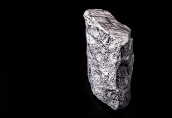 Raw manganese. Manganese stone isolated on black background. Mineral extraction of heavy metals.