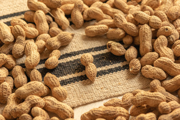 loose and unshelled peanuts in a tablecloth and white wooden table