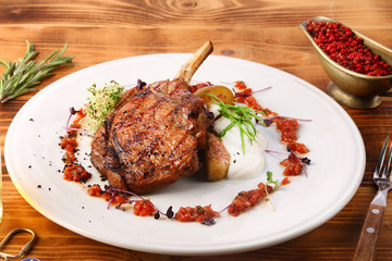 freshly grilled hot steaks with potato on wooden table and beer in glass