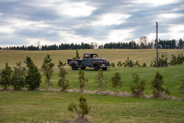 Old historic rusty truck in the field with cloudy skies