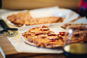 A couple of men and women eat pizza on the sofa in their living room at night while watching a movie on television. Concept of life as a couple at home.