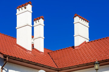 an orange rooftop of a ceramic tile with a pipe a storm drainage system, close up details of the architectural structure on sunny day.