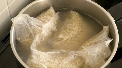 cooking pearl barley porridge in bags on electric cooker