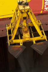 Loading coal from cargo barges onto a bulk vessel using ship cranes  in offshore coal cargo terminal.
