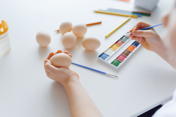 Baby hands holding Easter eggs on a white background. Child painting eggs. Happy daughter preparing for Easter