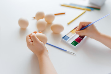 Baby hands holding Easter eggs on a white background. Child painting eggs. Happy daughter preparing for Easter