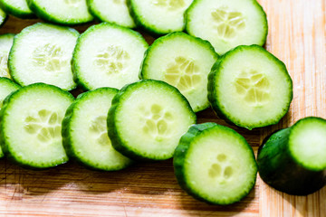 Cucumber cut slices on wooden cutting board