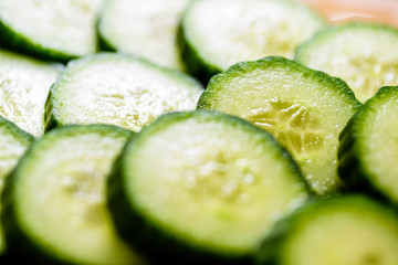 Cucumber cut slices on wooden cutting board