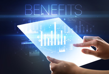 Hand holding futuristic tablet with BENEFITS inscription above, modern business concept