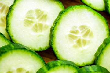 Cucumber cut slices on wooden cutting board