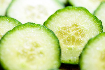 Cucumber cut slices on wooden cutting board