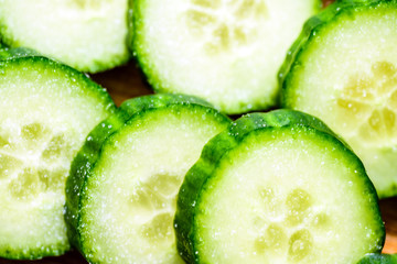 Cucumber cut slices on wooden cutting board