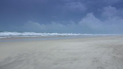 Fototapeta na wymiar Empty sandy beach on a rainy day - Atlantic ocean