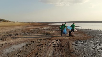 A group of volunteers collect plastic film on the coast. - Powered by Adobe
