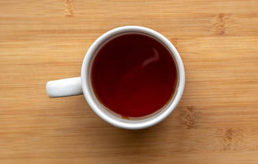 top view of cup of tea on a wooden table.