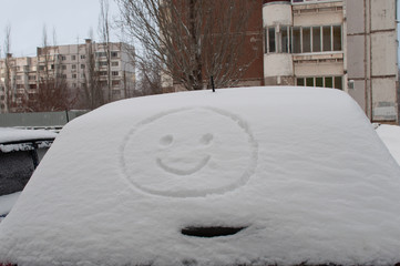 smiley on a car in the snow