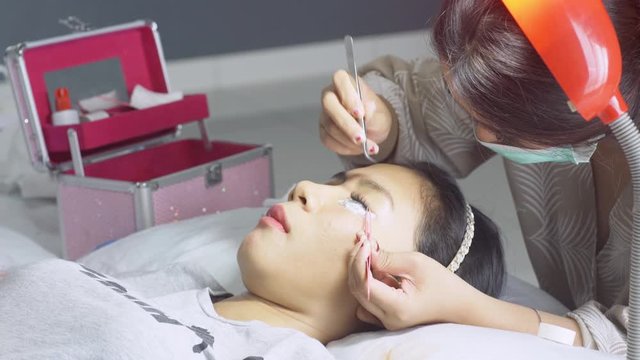 Beautician undergoing eyelash extension procedure