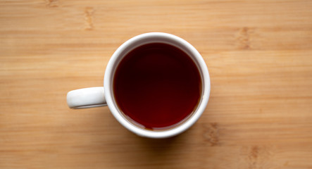 top view of cup of tea on a wooden table.