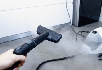 cleaning the floor of the house with a steam cleaner, disinfection of the room.