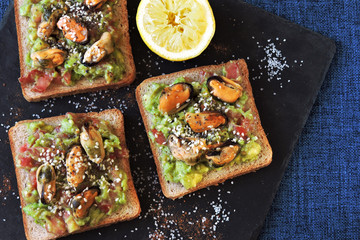 Guacamole toasts with mussels. Healthy snack. Keto diet.
