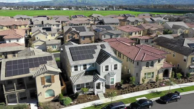 Aerial view above residential neighborhood houses with clean solar renewable energy panels on rooftops