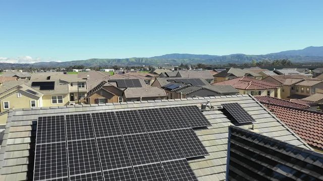 Solar project renewable energy panels on rooftops. Aerial revealing neighborhood homes