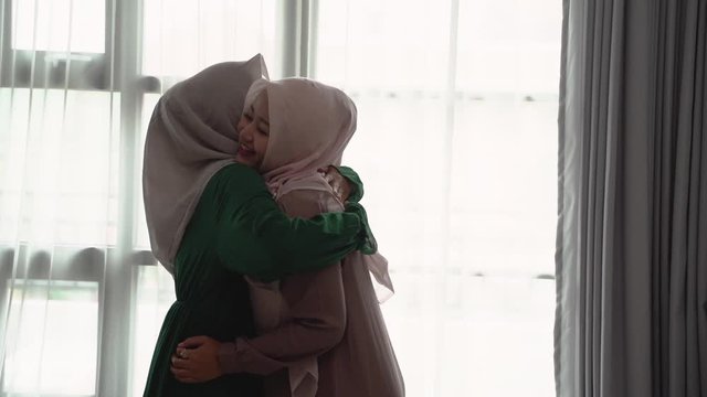 muslim hijab woman happily entrace home opens the door meets and hug her sister