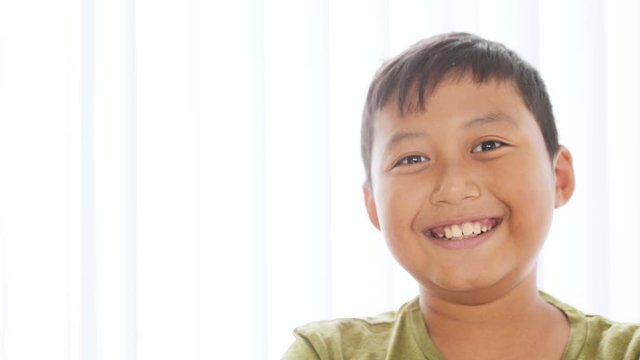 Preteen boy laughing and looking at the camera