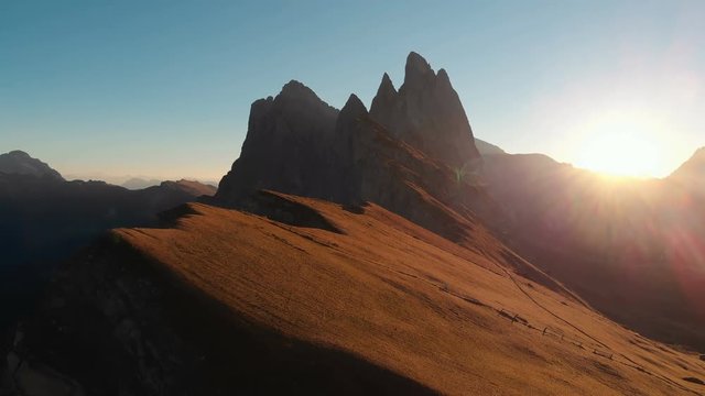 Aerial Drone Footage View on Majestic panorama of beautiful sunset or sunrise in the Italian picturesque resort Seceda dolomite mountains. Beautiful landscape near the edge of world at 4K resolution.