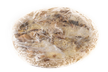 Frozen pizza wrapped in plastic isolated on a white background.