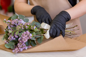 Lilac in the hands of a florist girl who creates a bouquet in a flower shop