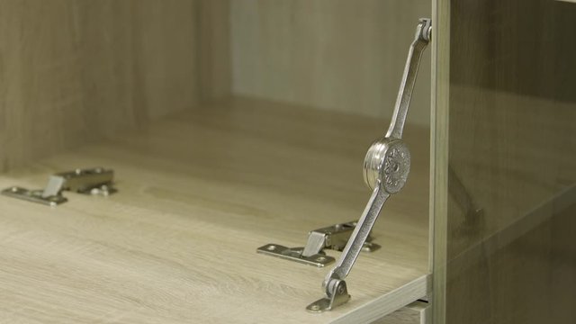 A gray door from chest of drawers opens smoothly with a automatic mechanism.