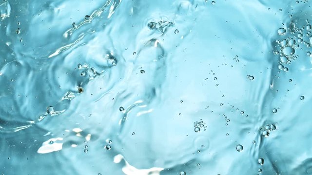 Water splashing on blue background, super slow motion. Filmed on high speed cinema camera, 1000 fps.