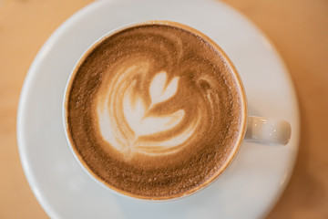 top view Cup of art latte or cappuccino coffee on wood table