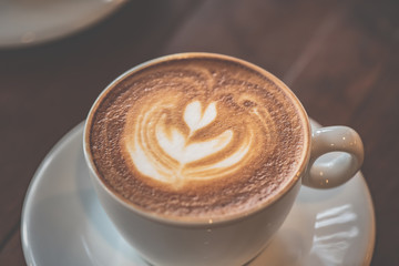 top view Cup of art latte or cappuccino coffee on wood table