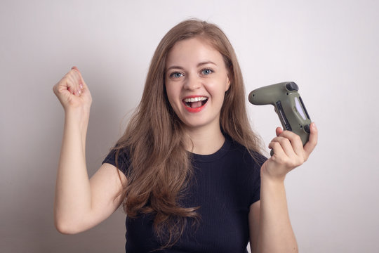 Smiling young caucasian woman girl holding joystick game pad controller, playing computer game.