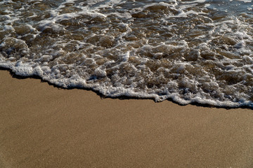 Close up of  sea wave on sandy beach