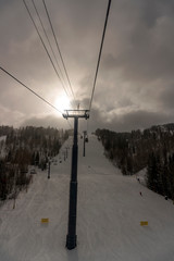 Panorama with ski slope and ski lifts on a cloudy day