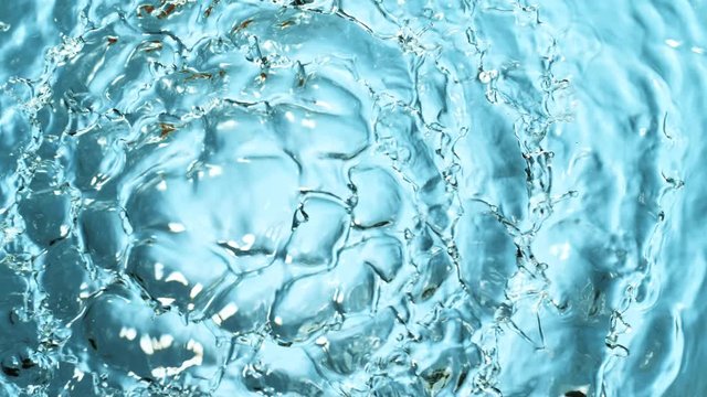 Water splashing on blue background, super slow motion. Filmed on high speed cinema camera, 1000 fps.