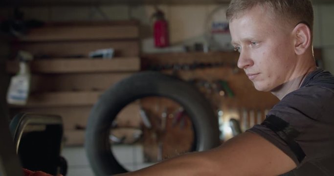 Mechanic typing on tire changer's control desk on tire mounting