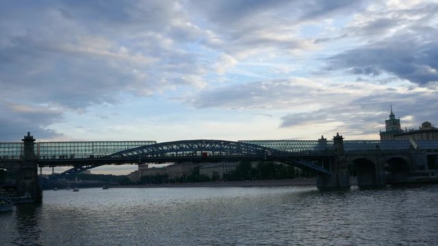 Crowd of people walking inside Pushkinskiy glass Bridge above Moskva river