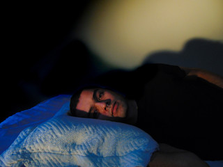 Hombre en su cama intentando dormir, estrés ansiedad, preocupación, cansancio, tristeza, depresión, concentrado...
