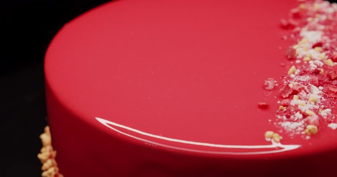 Making a red icing cake decorated with peanuts